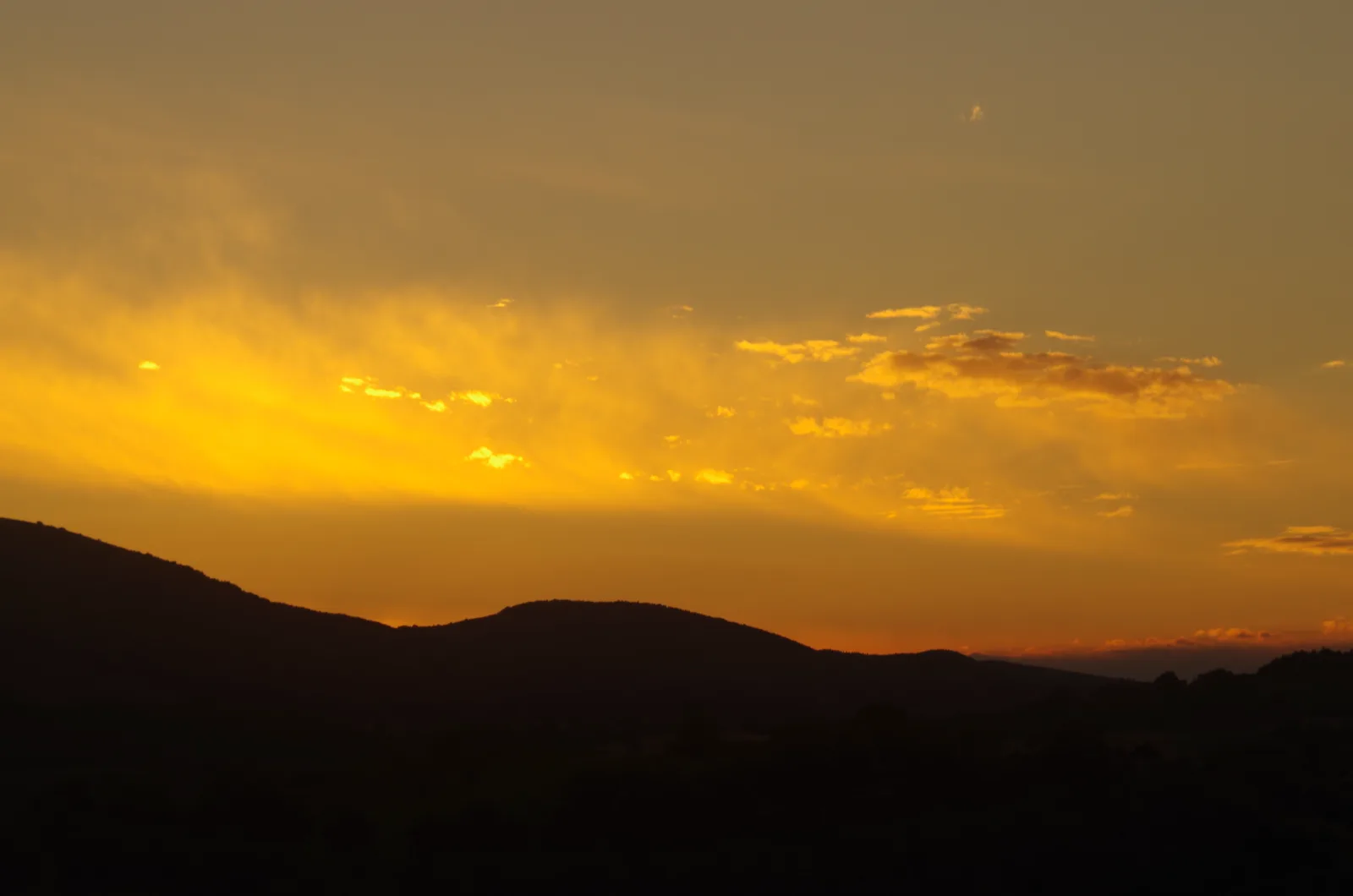 Golden sunset sky over silhouetted hills